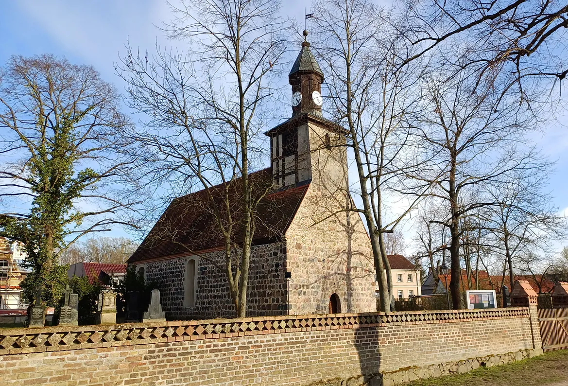Historische, ländliche Kirche aus Feldstein mit Friedhof, typischer Bauweise und ruhiger Umgebung