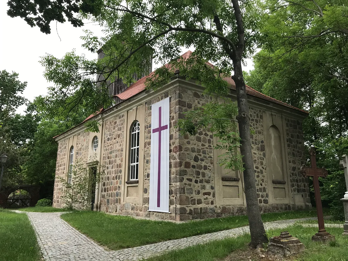 Malerische, historische Dorfkirche mit Friedhof, in idyllischer Lage und gepflegtem Zustand. Die liturgische Kirchenfahne wird zu Pfingsten aufgehangen.