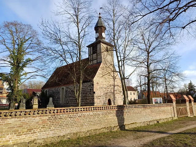 Feldsteinkirche mit Kirchmauer und Grabmalen