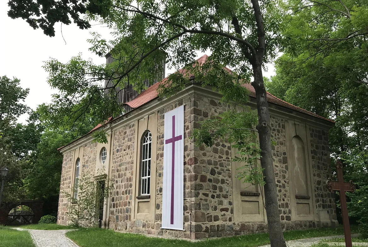 Malerische, historische Dorfkirche mit Friedhof, in idyllischer Lage und gepflegtem Zustand. Die liturgische Kirchenfahne wird zu Pfingsten aufgehangen.